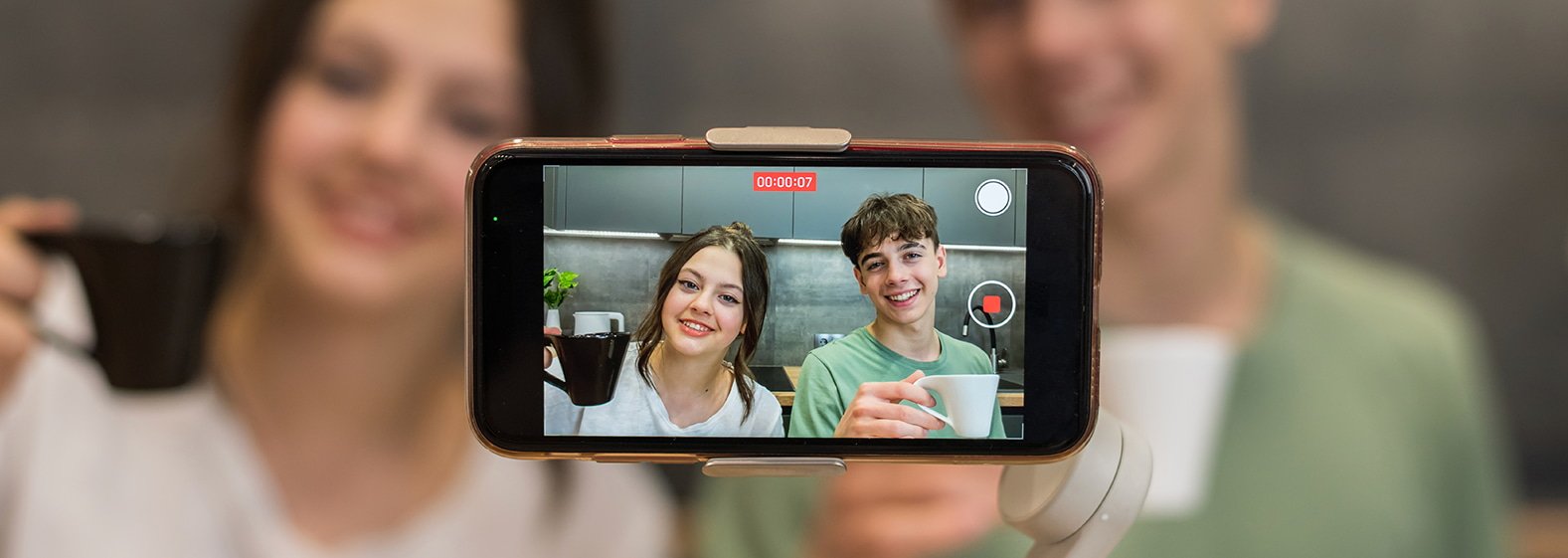 Dos influencers grabándose con su celular mientras muestran un producto como parte de una campaña de marketing digital.